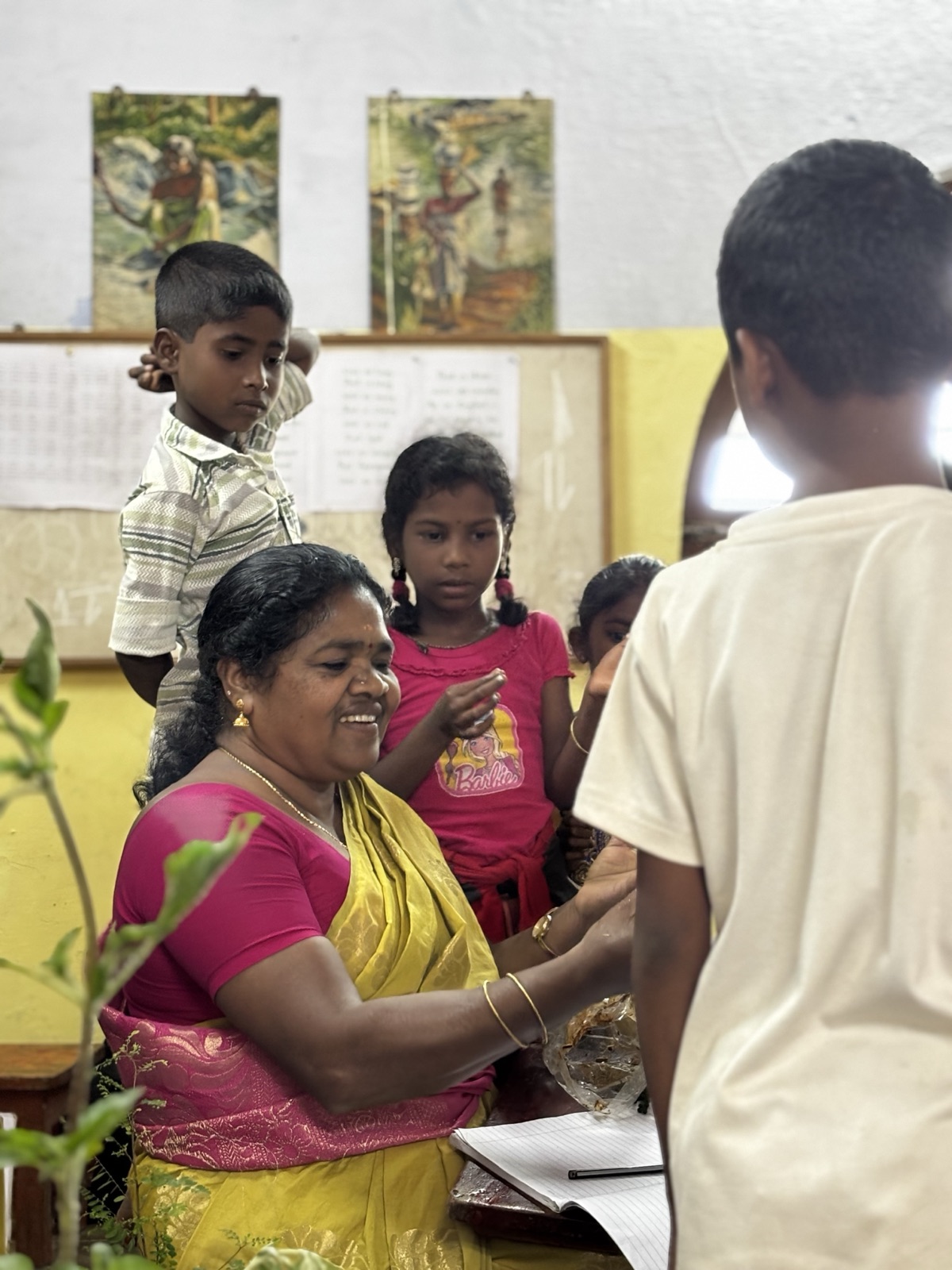 An Adivasi teacher laughing with her students at Vidyodaya